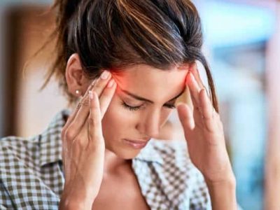 Shot of a uncomfortable looking woman holding her head in discomfort due to pain at home during the day